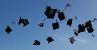 Graduation hats being thrown in the air